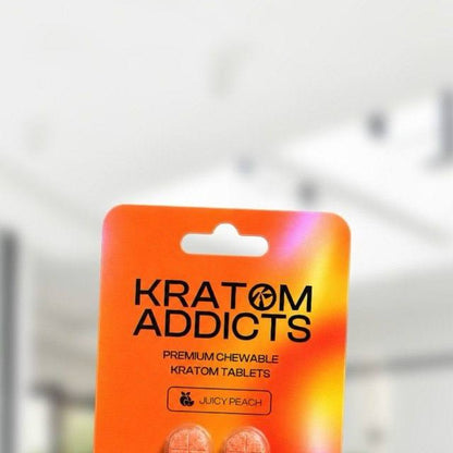 A hand holding Juicy Peach kratom tablets