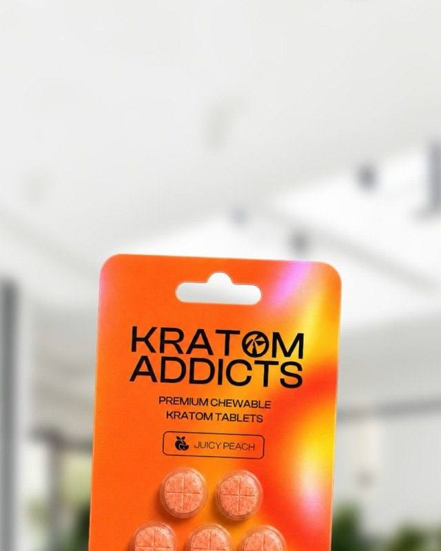 A hand holding Juicy Peach kratom tablets