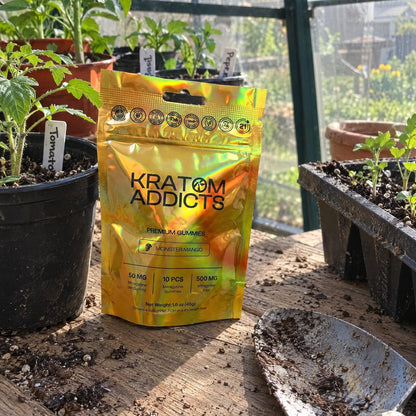 Monster Mango kratom gummies on a potting bench in a greenhouse