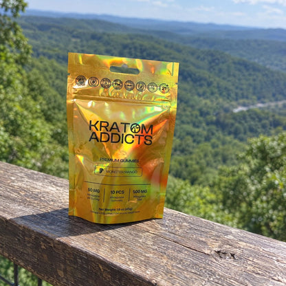 Monster Mango kratom gummies on a deck railing above a wooded valley