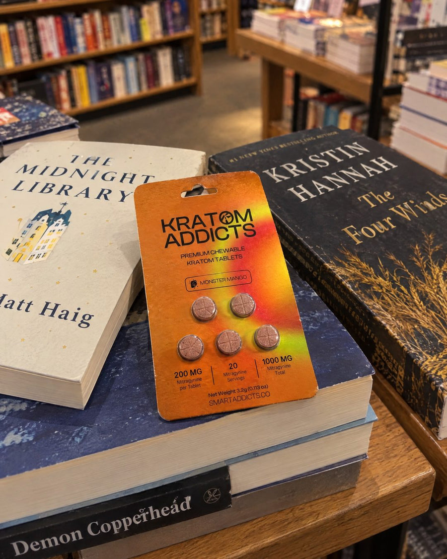 Monster Mango kratom tablets on a stack of books in a bookstore