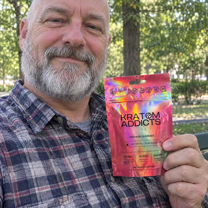 A man in a park holding Watermelon Wonder kratom gummies