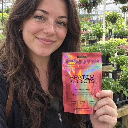 A woman in a greenhouse holding Watermelon Wonder kratom gummies